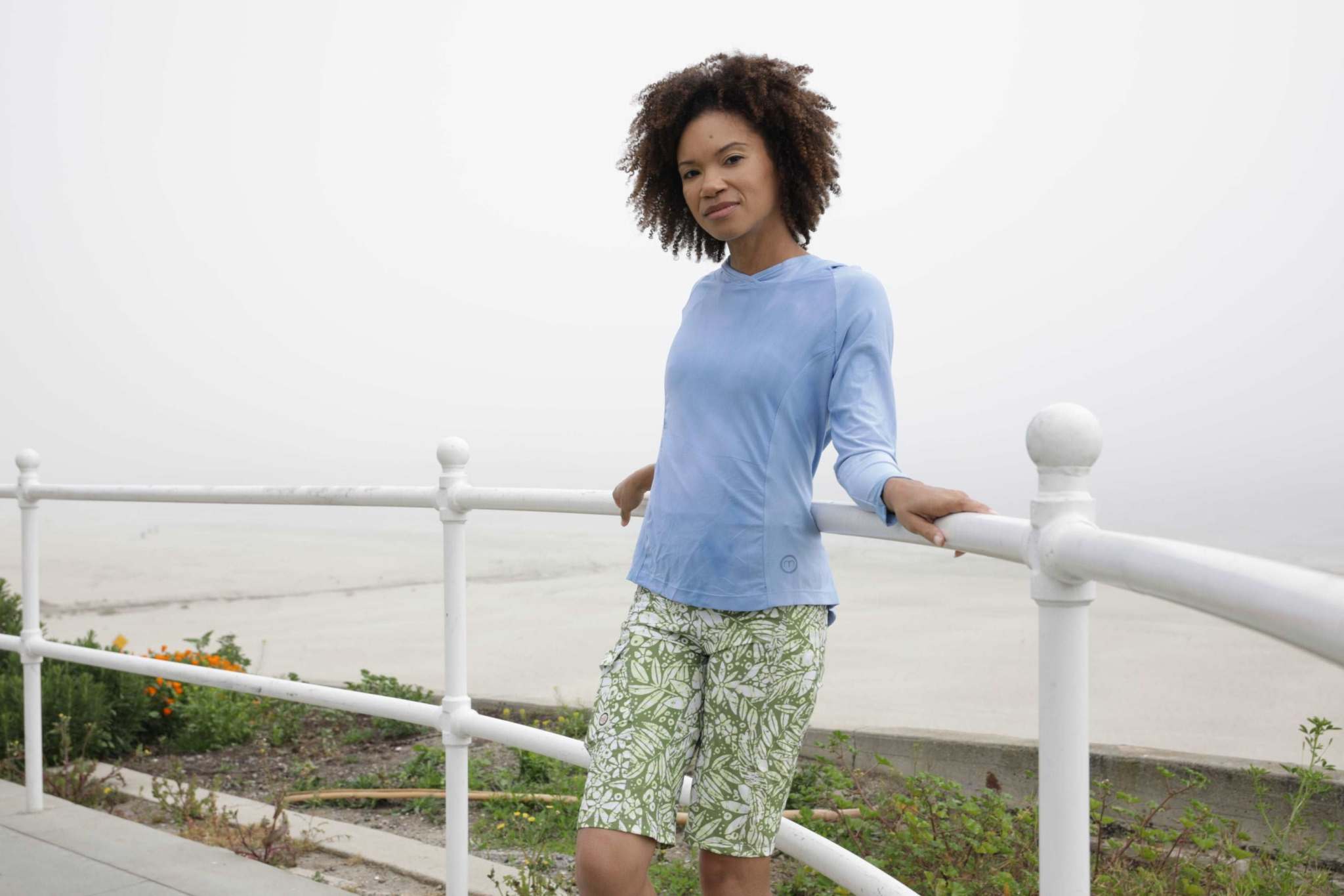 Woman wearing Mountain Short-Peace Leaf trail-ready shorts, outdoor setting.